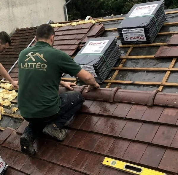 Couvreur Lattéo sur un toit ouvert à Corbeil-Essonnes : liteaux neufs, laine des combles visible, tuiles et faîtières prêtes à poser