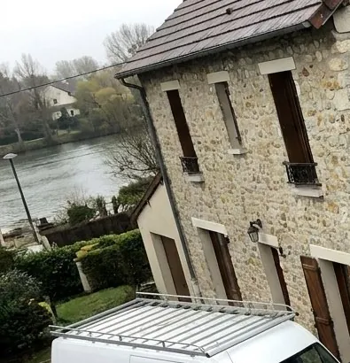 Maison en pierre et toit de tuiles plates au bord de la Seine à Corbeil-Essonnes, vue depuis le chantier de couverture